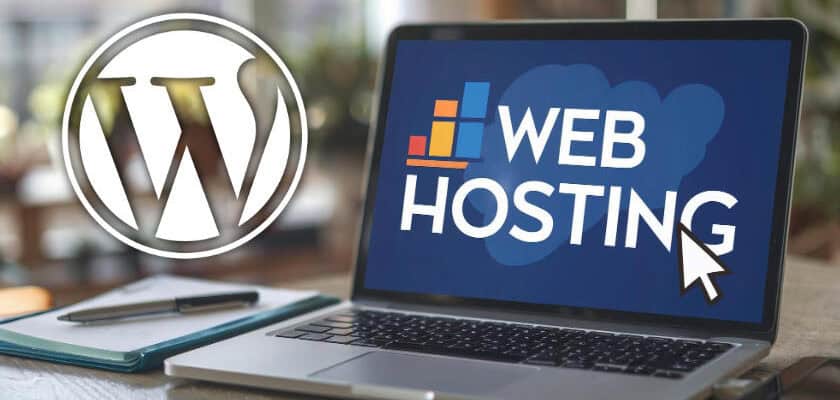 notebook su scrivania aperto con scritta web hosting su schermo e logo wordpress a sinistra con sfondo ambiente ufficio
